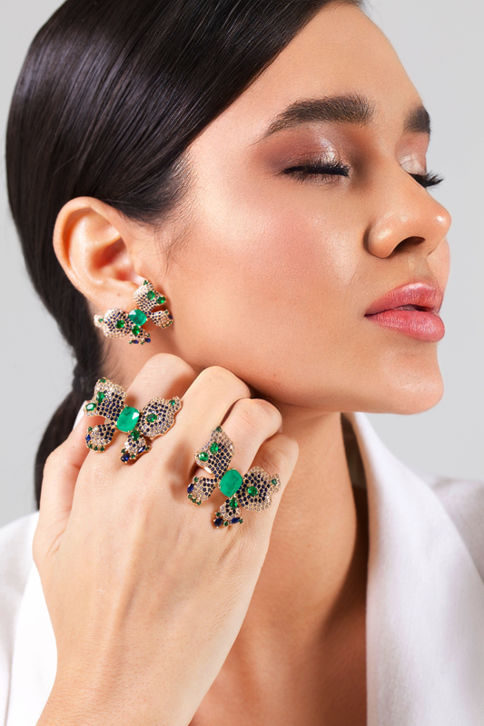 Butterfly set with zirconia and emeralds.